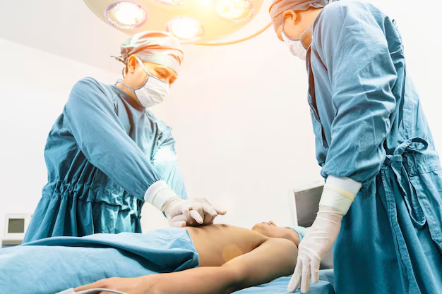 Deux professionnels de la santé en tenue chirurgicale effectuent une réanimation cardio-respiratoire (RCR) sur un patient allongé, illustrant la pratique des techniques de RCR, essentielle dans une formation hybride combinant théorie en ligne et exercices pratiques.