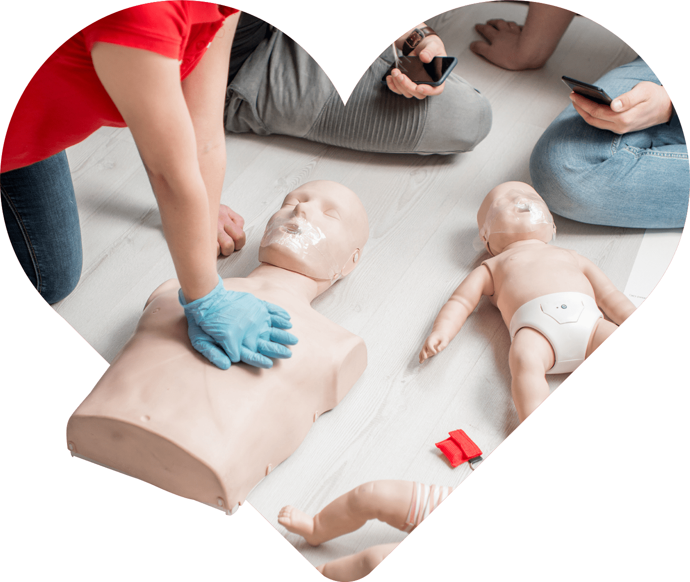 Personne effectuant des compressions thoraciques sur un mannequin de RCR, avec un défibrillateur automatisé externe (DAE) connecté. Cette scène représente la pratique des gestes de premiers secours dans le cadre d’une formation RCR hybride, mêlant théorie en ligne et exercices pratiques.